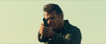 Movie still from “Taken 2” (2012), directed by Olivier Megaton – A man holding a gun in his hand; Close Up shot, Low angle