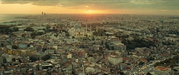 Movie still from “Taken 2” (2012), directed by Olivier Megaton – An aerial view of a large city at sunset; Extreme Wide shot, High angle