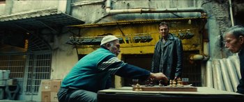 Movie still from “Taken 2” (2012), directed by Olivier Megaton – Two men are playing a game of chess in an alley; Wide shot, Low angle