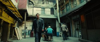 Movie still from “Taken 2” (2012), directed by Olivier Megaton – A man walking down the street with a cell phone in his hand; Wide shot, Low angle