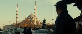 Movie still from “Taken 2” (2012), directed by Olivier Megaton – A man standing in front of a large building; Wide shot, Low angle