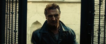 Movie still from “Taken 2” (2012), directed by Olivier Megaton – A man wearing a leather jacket standing in front of a wall; Close Up shot, Low angle