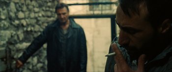 Movie still from “Taken 2” (2012), directed by Olivier Megaton – A man standing next to another man smoking a cigarette; Close Up shot, Over the shoulder angle