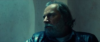 Movie still from “Taken 2” (2012), directed by Olivier Megaton – An older man with a beard and a leather jacket; Close Up shot, Low angle