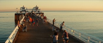 Movie still from “Taken 2” (2012), directed by Olivier Megaton – A group of people fishing on a pier at sunset; Extreme Wide shot, High angle