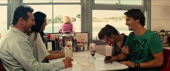 Movie still from “Taken 2” (2012), directed by Olivier Megaton – A group of people sitting at a table with drinks; Medium shot, Over the shoulder angle