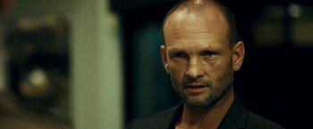 Movie still from “Taken 3” (2014), directed by Olivier Megaton – A person wearing a suit; Close Up shot, Over the shoulder angle