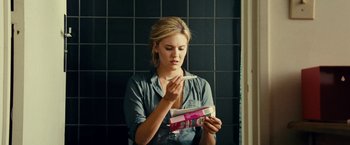 Movie still from “Taken 3” (2014), directed by Olivier Megaton – A woman is looking down at a box of chewing gum; Medium shot, Over the shoulder angle