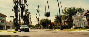 Movie still from “Taken 3” (2014), directed by Olivier Megaton – Cars driving down a street lined with palm trees; Extreme Wide shot, Low angle