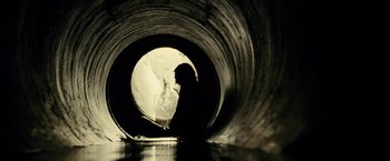 Movie still from “Taken 3” (2014), directed by Olivier Megaton – A man sitting in a pipe in the middle of a pool; Wide shot, High angle