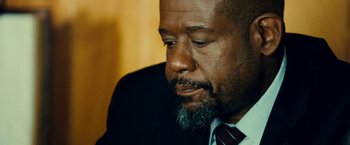 Movie still from “Taken 3” (2014), directed by Olivier Megaton – A person wearing a suit and tie; Close Up shot, Over the shoulder angle