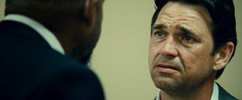 Movie still from “Taken 3” (2014), directed by Olivier Megaton – A man is looking at another man in a room; Close Up shot, Over the shoulder angle