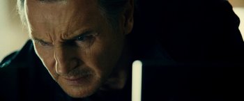 Movie still from “Taken 3” (2014), directed by Olivier Megaton – A man's face with a candle in front of him; Close Up shot, Low angle