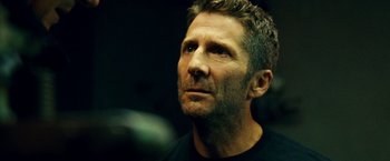 Movie still from “Taken 3” (2014), directed by Olivier Megaton – A person wearing a black t - shirt; Close Up shot, Low angle