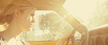 Movie still from “Taken 3” (2014), directed by Olivier Megaton – A woman driving a car in the sunlight; Close Up shot, Low angle