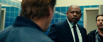 Movie still from “Taken 3” (2014), directed by Olivier Megaton – A man in a suit is looking at himself in the mirror; Close Up shot, Over the shoulder angle