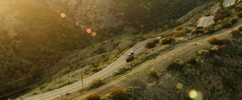 Movie still from “Taken 3” (2014), directed by Olivier Megaton – An aerial view of a car driving down a road; Extreme Wide shot, High angle