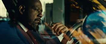 Movie still from “Taken 3” (2014), directed by Olivier Megaton – A man in a suit holding a cell phone; Close Up shot, Low angle