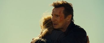 Movie still from “Taken 3” (2014), directed by Olivier Megaton – A man and a woman are hugging in a field; Close Up shot, Low angle