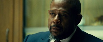 Movie still from “Taken 3” (2014), directed by Olivier Megaton – A person wearing a suit and tie; Close Up shot, Over the shoulder angle