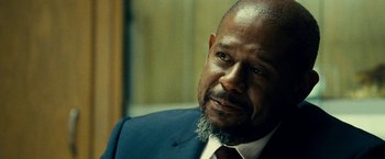 Movie still from “Taken 3” (2014), directed by Olivier Megaton – A man in a blue suit and a red tie; Close Up shot, Over the shoulder angle