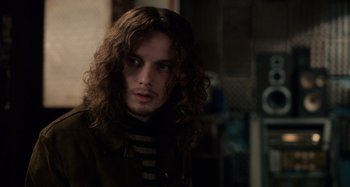 Movie still from “Only Lovers Left Alive” (2013), directed by Jim Jarmusch – A man with long curly hair is looking at the camera; Close Up shot, Over the shoulder angle