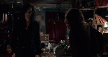 Movie still from “Only Lovers Left Alive” (2013), directed by Jim Jarmusch – Two people standing in a room with a drum set in the background; Medium shot, Over the shoulder angle