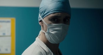 Movie still from “Only Lovers Left Alive” (2013), directed by Jim Jarmusch – A man wearing a surgical mask and a surgical cap; Close Up shot, Low angle