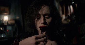 Movie still from “Only Lovers Left Alive” (2013), directed by Jim Jarmusch – A woman holding a glass of red wine in front of her face; Close Up shot, High angle
