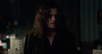Movie still from “Only Lovers Left Alive” (2013), directed by Jim Jarmusch – A man with long curly hair is standing in the dark; Close Up shot, Over the shoulder angle