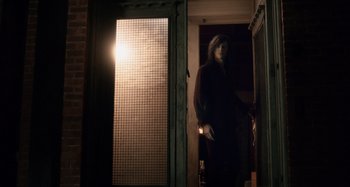 Movie still from “Only Lovers Left Alive” (2013), directed by Jim Jarmusch – A woman standing in a dark doorway holding a flashlight; Wide shot, Over the shoulder angle