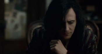 Movie still from “Only Lovers Left Alive” (2013), directed by Jim Jarmusch – A man with long black hair is holding his hand to his face; Close Up shot, Over the shoulder angle