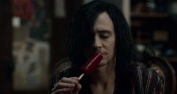 Movie still from “Only Lovers Left Alive” (2013), directed by Jim Jarmusch – A man with long black hair is eating a popsicle; Close Up shot, Over the shoulder angle