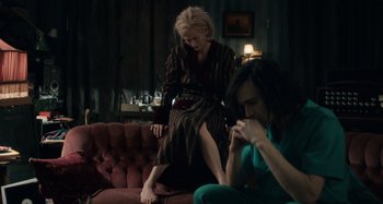 Movie still from “Only Lovers Left Alive” (2013), directed by Jim Jarmusch – Two people sitting on a couch in a living room; Wide shot, High angle
