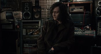 Movie still from “Only Lovers Left Alive” (2013), directed by Jim Jarmusch – A man sitting in front of a bunch of sound equipment; Medium shot, Over the shoulder angle
