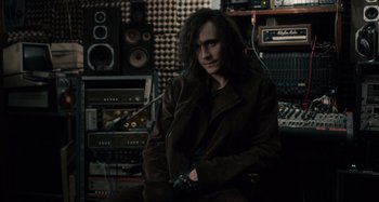 Movie still from “Only Lovers Left Alive” (2013), directed by Jim Jarmusch – A man sitting in front of a bunch of sound equipment; Medium shot, Over the shoulder angle