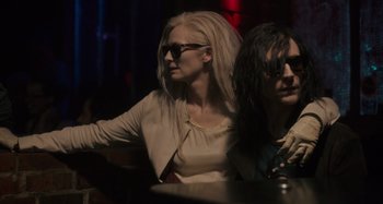 Movie still from “Only Lovers Left Alive” (2013), directed by Jim Jarmusch – A woman sitting next to another woman at a table; Medium shot, Over the shoulder angle