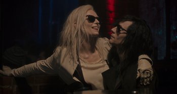 Movie still from “Only Lovers Left Alive” (2013), directed by Jim Jarmusch – A woman and a man sitting next to each other at a table; Medium shot, Over the shoulder angle