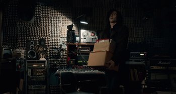 Movie still from “Only Lovers Left Alive” (2013), directed by Jim Jarmusch – A man holding a box in a recording studio; Medium shot, Low angle