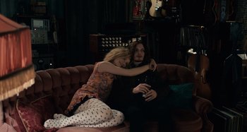 Movie still from “Only Lovers Left Alive” (2013), directed by Jim Jarmusch – A man and a woman sitting on top of a pink couch; Medium shot, High angle