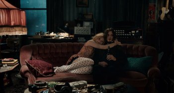 Movie still from “Only Lovers Left Alive” (2013), directed by Jim Jarmusch – A man and a woman sitting on top of a red couch; Wide shot, High angle