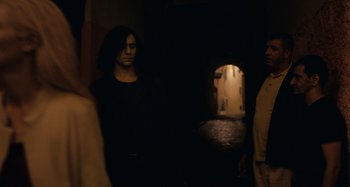 Movie still from “Only Lovers Left Alive” (2013), directed by Jim Jarmusch – A man standing next to another man in a dark room; Medium shot, Over the shoulder angle