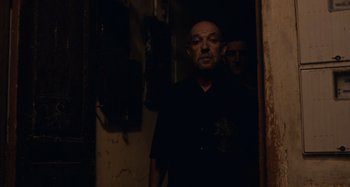 Movie still from “Only Lovers Left Alive” (2013), directed by Jim Jarmusch – A man standing in a dark room with another man standing next to him; Medium shot, Low angle