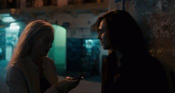 Movie still from “Only Lovers Left Alive” (2013), directed by Jim Jarmusch – A woman holding a cell phone in front of another woman; Medium shot, Over the shoulder angle