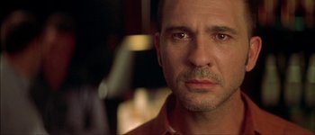 Movie still from “Talk to Her” (2002), directed by Pedro Almodóvar – A man's face in a dark room; Close Up shot, Over the shoulder angle