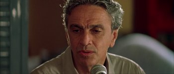 Movie still from “Talk to Her” (2002), directed by Pedro Almodóvar – A person holding a microphone; Close Up shot, Low angle