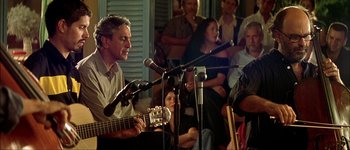 Movie still from “Talk to Her” (2002), directed by Pedro Almodóvar – A man is playing a guitar in front of an audience; Medium shot, Over the shoulder angle