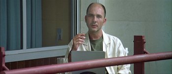 Movie still from “Talk to Her” (2002), directed by Pedro Almodóvar – A man sitting in front of a window smoking a cigarette; Close Up shot, Low angle