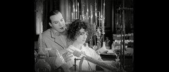Movie still from “Talk to Her” (2002), directed by Pedro Almodóvar – A man and a woman are looking at a bottle of wine; Medium shot, Over the shoulder angle