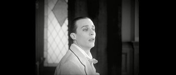 Movie still from “Talk to Her” (2002), directed by Pedro Almodóvar – A man with a bow tie is standing in front of a window; Close Up shot, Low angle